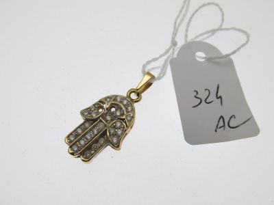 un gros plan sur une petite main de Hamsa en or sertie de diamants