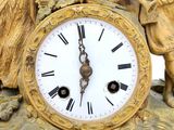 a gold clock with angels on top of it