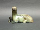 a figurine of a horse laying down on a gray surface