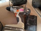 a cordless drill and two batteries on a counter