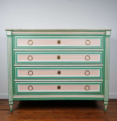 une commode verte et rose avec des poignées dorées