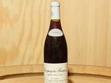 une bouteille de vin posée sur un tonneau