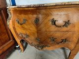 a wooden chest of drawers with a marble top