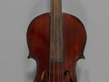 an old violin is hanging on a wall in a room