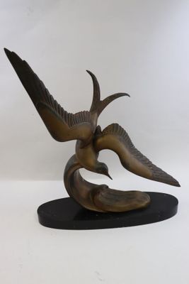 sculpture en bronze représentant un oiseau sur un socle noir, sur fond blanc