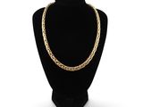 un collier à chaîne en or sur un présentoir à mannequin