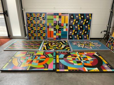 Plusieurs œuvres d'art sont disposées sur le sol dans une pièce