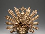 a gold statue of a bird with a crown on it ' s head