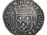 une pièce d'argent surmontée d'une couronne