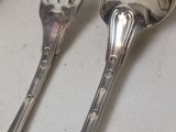 two spoons and a fork sitting on a table