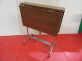 a small folding table on a metal stand on a red floor