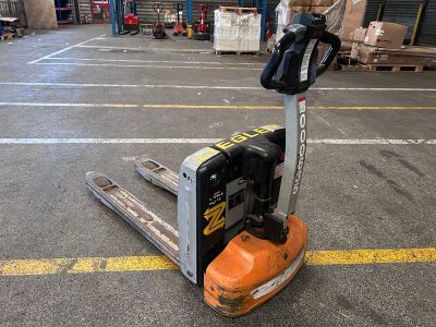 un chariot élévateur à fourche stationné au sol dans un entrepôt