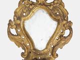un cadre doré avec un miroir, accroché au mur