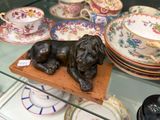une statue représentant un chien couché sur une assiette