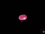 a close up of a pink stone on a black surface