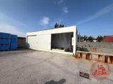 an empty parking lot in front of a building with blue crates