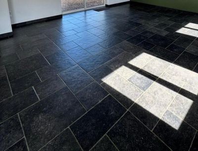 a black tile floor in an empty room with a sliding glass door