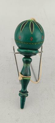 a green lamp that is on a stand on a white surface