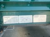an image of a green dump truck parked in a parking lot