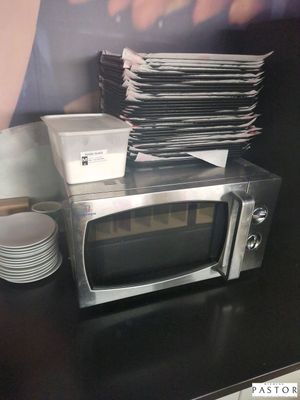 un micro-ondes posé sur une table sur laquelle se trouvent des assiettes