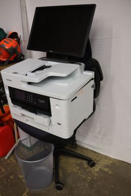 a printer sitting on top of a cart in a garage
