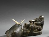 a sculpture of a person laying down with a knife in their hand