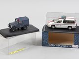 deux petites voitures dans une vitrine posée sur une table