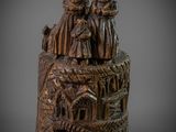 une vieille figurine en bronze représentant un groupe de personnes sur un rocher