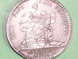 a close up of a silver coin with a statue on it