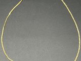 un collier en or dont la chaîne a été coupée en deux