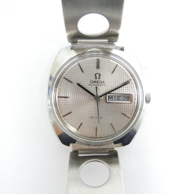 une montre en argent posée sur une surface blanche