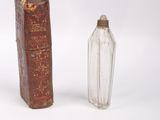 a small glass bottle next to a small glass bottle