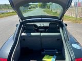 a car with its trunk open on the side of the road