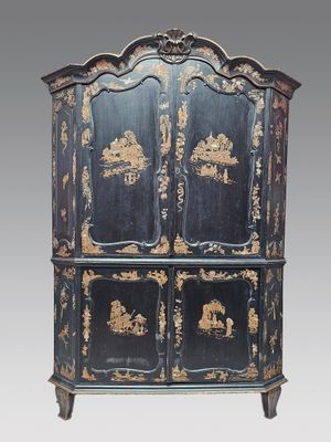 une photo d'une commode peinte en noir et or, dotée de quatre tiroirs