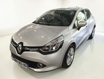La voiture argentée est garée sur le sol blanc de la pièce.