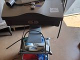 une petite table sur laquelle se trouvent un ordinateur portable et d'autres objets