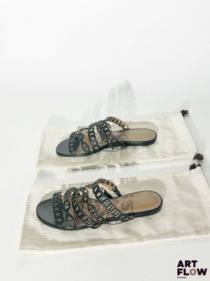 deux paires de sandales noires et blanches posées sur un sac blanc