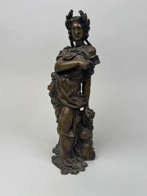 a bronze statue of a woman with a bird on her shoulder