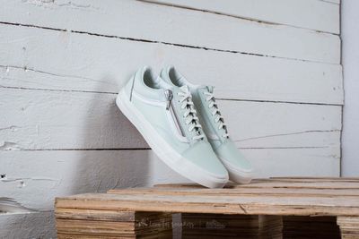 des Vans Old Skool blanches posées sur une caisse en bois