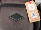 a brown and black bag with a tag on it