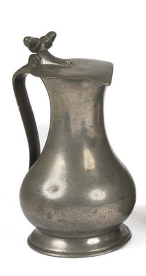a silver pitcher with a bird on it on a white background