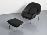 an image of a black chair and ottoman in a white room