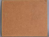 a close up of a square brown tile on a gray surface