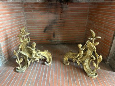 deux statues en or posées sur un sol en briques, près d'un mur en briques