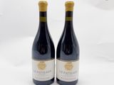 deux bouteilles de vin rouge posées l'une à côté de l'autre sur une surface blanche