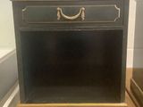 an antique black nightstand with gold trim and a drawer