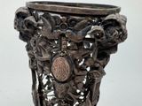 a silver vase that has a medallion on it