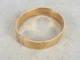 gros plan d'une bague en or sur une surface blanche