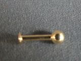 a gold nose ring with a ball on it