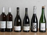plusieurs bouteilles de vin sont alignées sur une table en bois